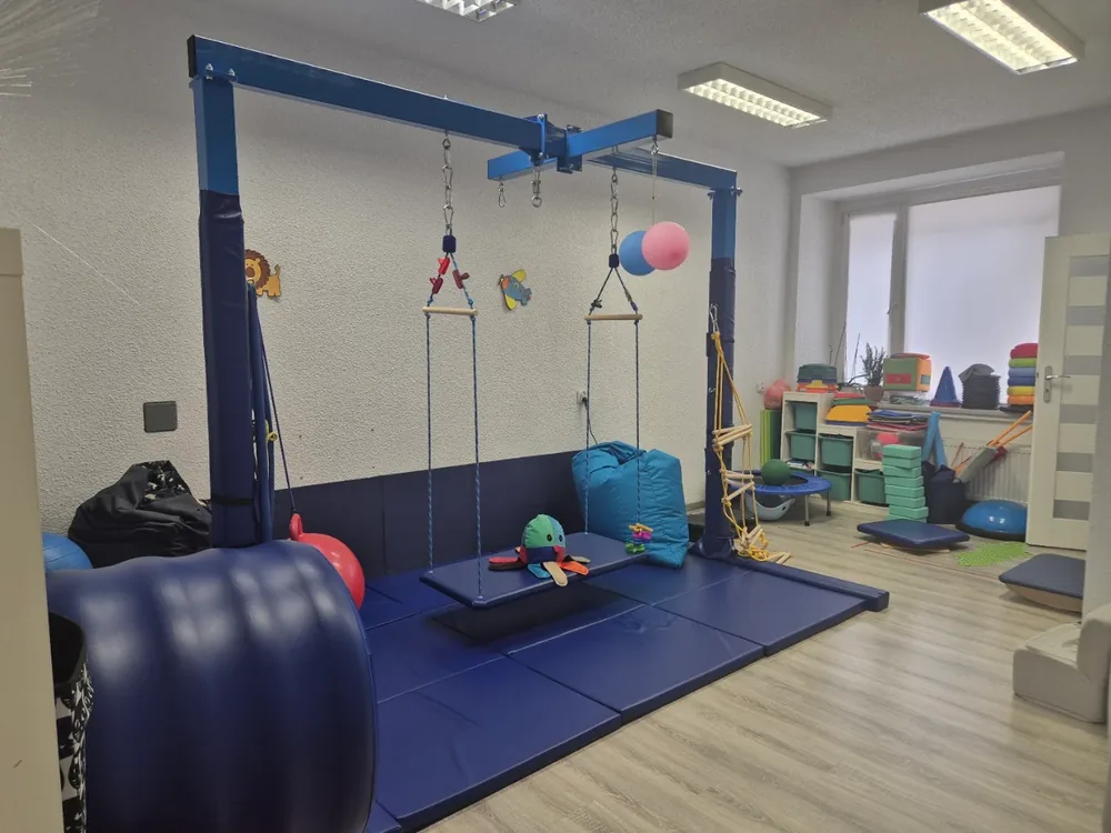 Sala integracji sensorycznej w SensoTerapii: podwieszana huśtawka, materace i pomoce do ćwiczeń